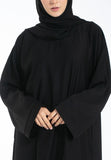 Person wearing a black abaya on a white background