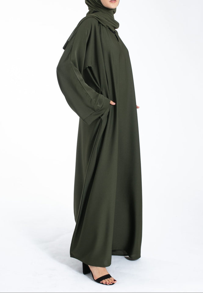 Woman wearing an olive green abaya on a white background