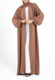Woman wearing a brown abaya on a white background